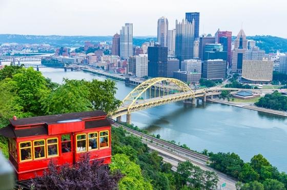 Photo of the Pittsburgh skyline featuring Mount Washington 和 a red incline car. 